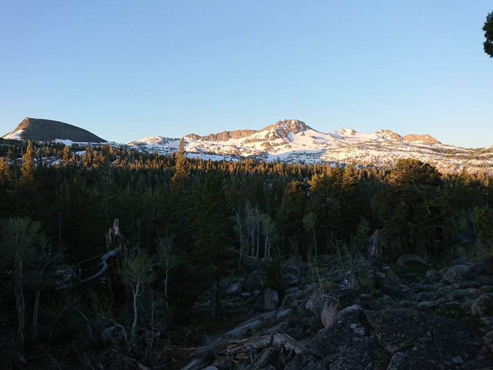  The sun is starting to light some of the mountains in the distance 